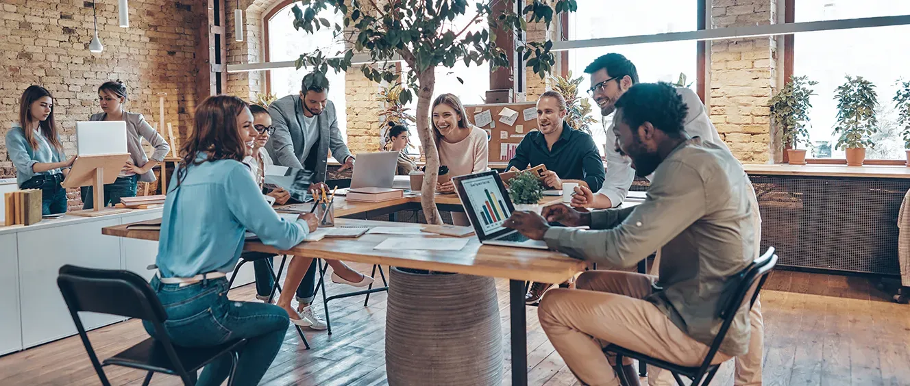 Group of people with laptops sitting in a room together