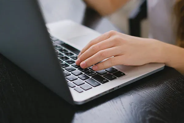 Person typing on macbook laptop